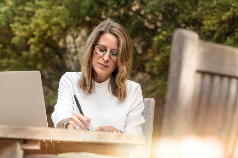 Woman writing while seated outdoors