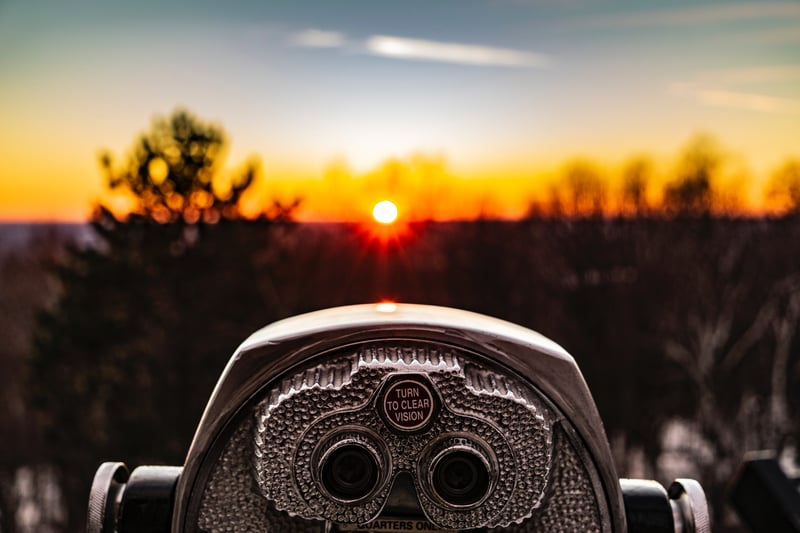 Binoculars pointed towards a sunset
